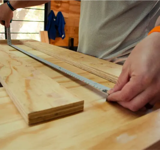 Close-up of artisan measuring wood for handcrafted live edge tables in Ottawa.