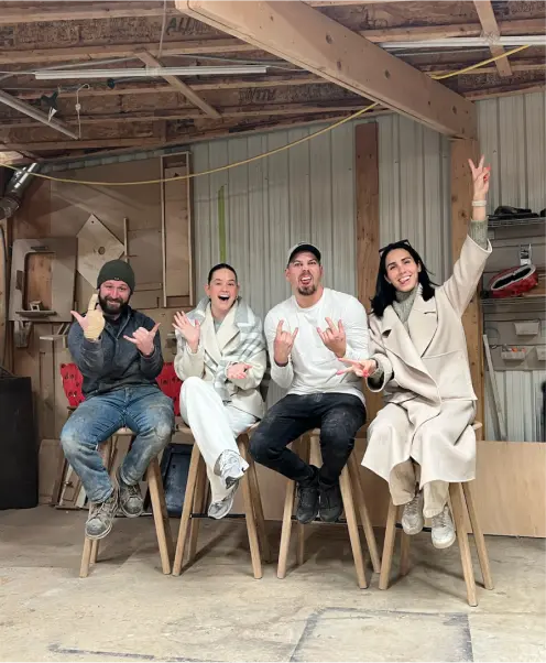 Group of craftsmen and designers in a woodshop, smiling and celebrating their work creating live edge tables in Ottawa.