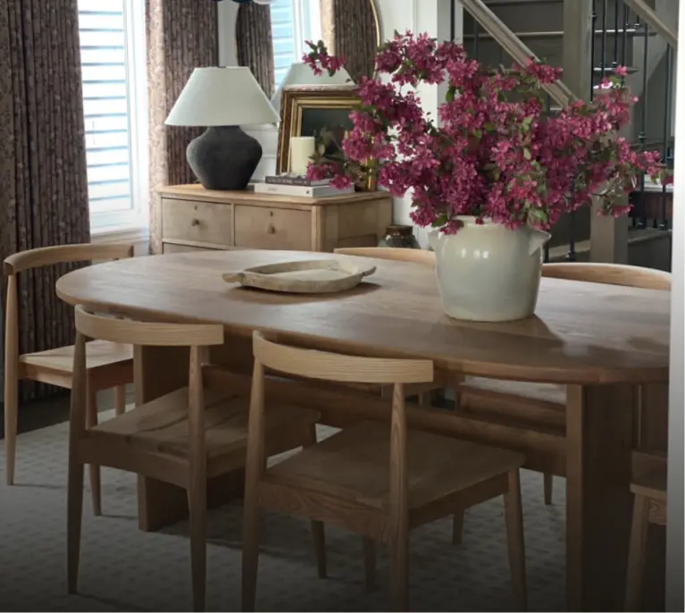 A handcrafted live edge dining table in an Ottawa home, styled with wooden chairs and a floral centerpiece.