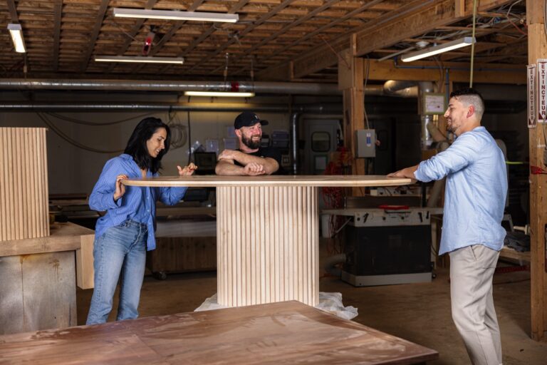 Woodworkers collaborating in an Ottawa workshop while building a handcrafted live edge table.